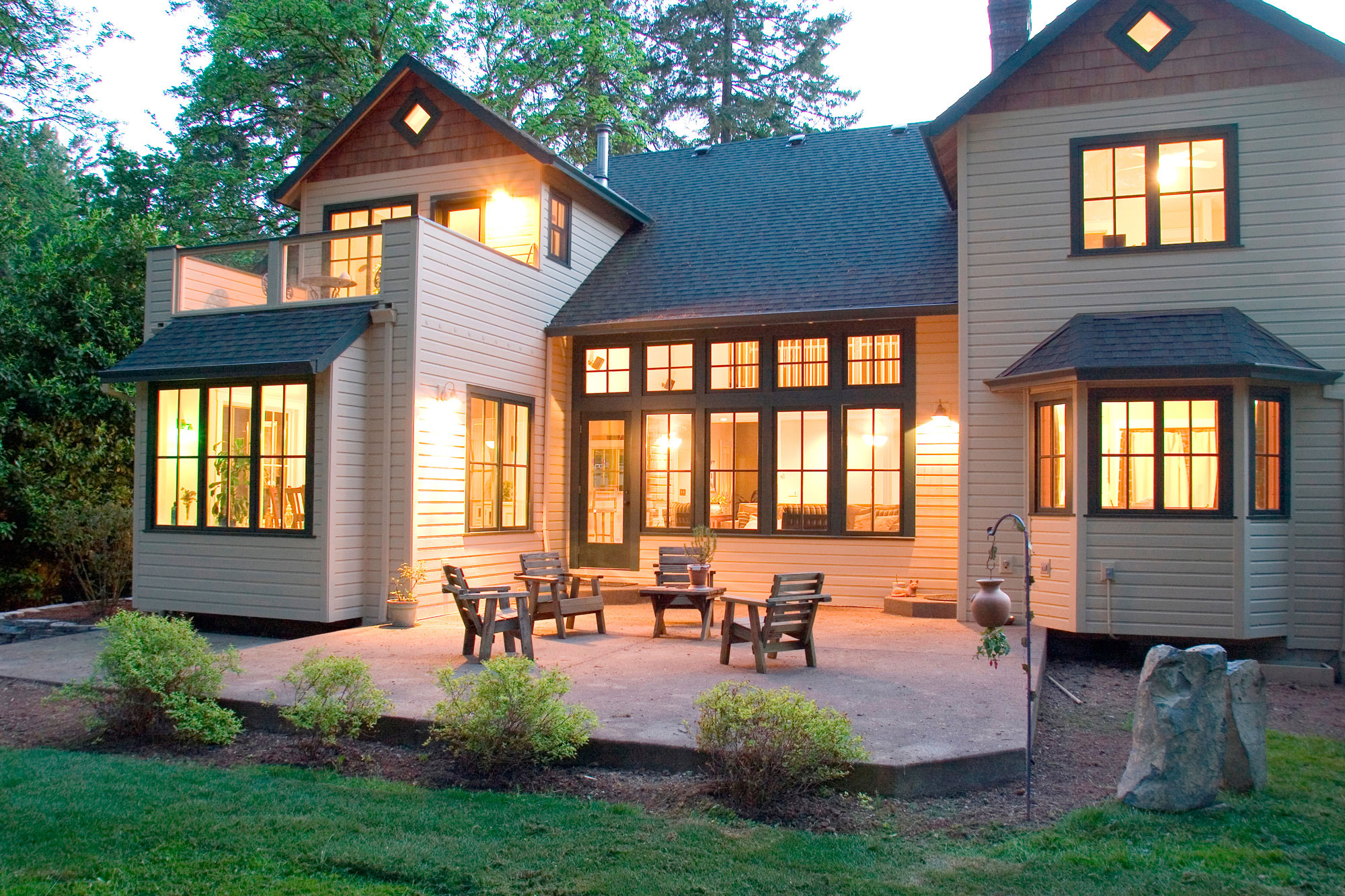 tan house with interior lights shining through windows 