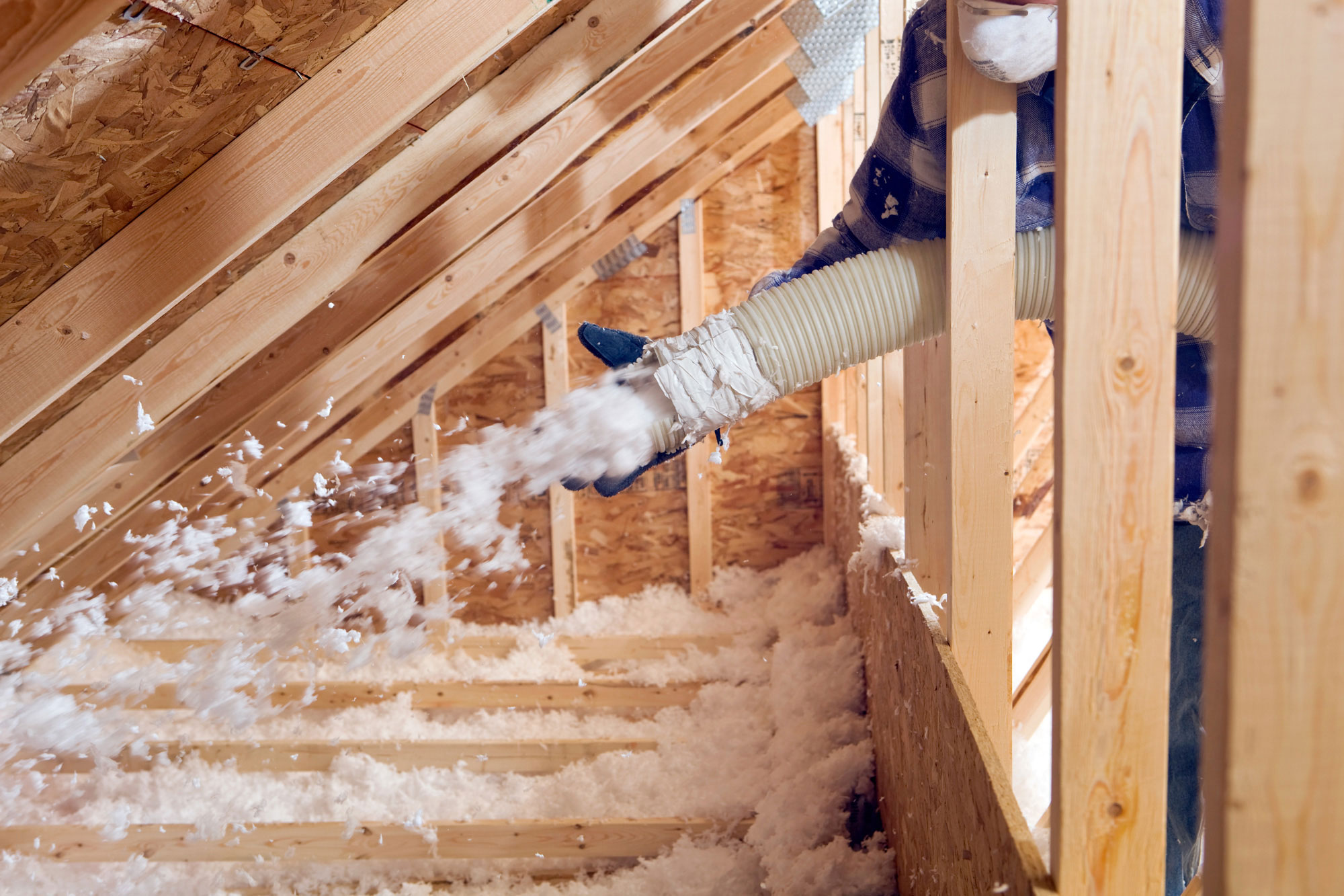 contractor blowing insulation in attic 